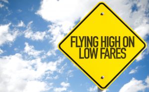 Flying High on Low Fares sign with sky background